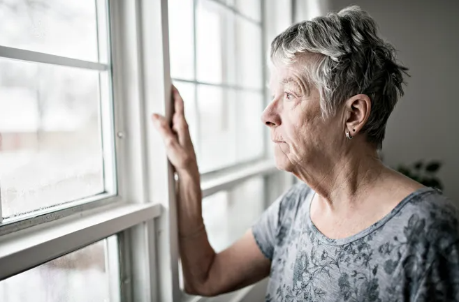 Woman isolated at home while staring out the window