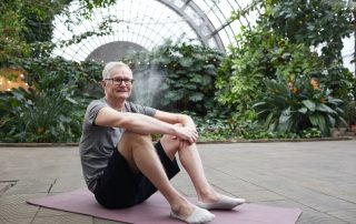 Older man sitting on a yoga mat
