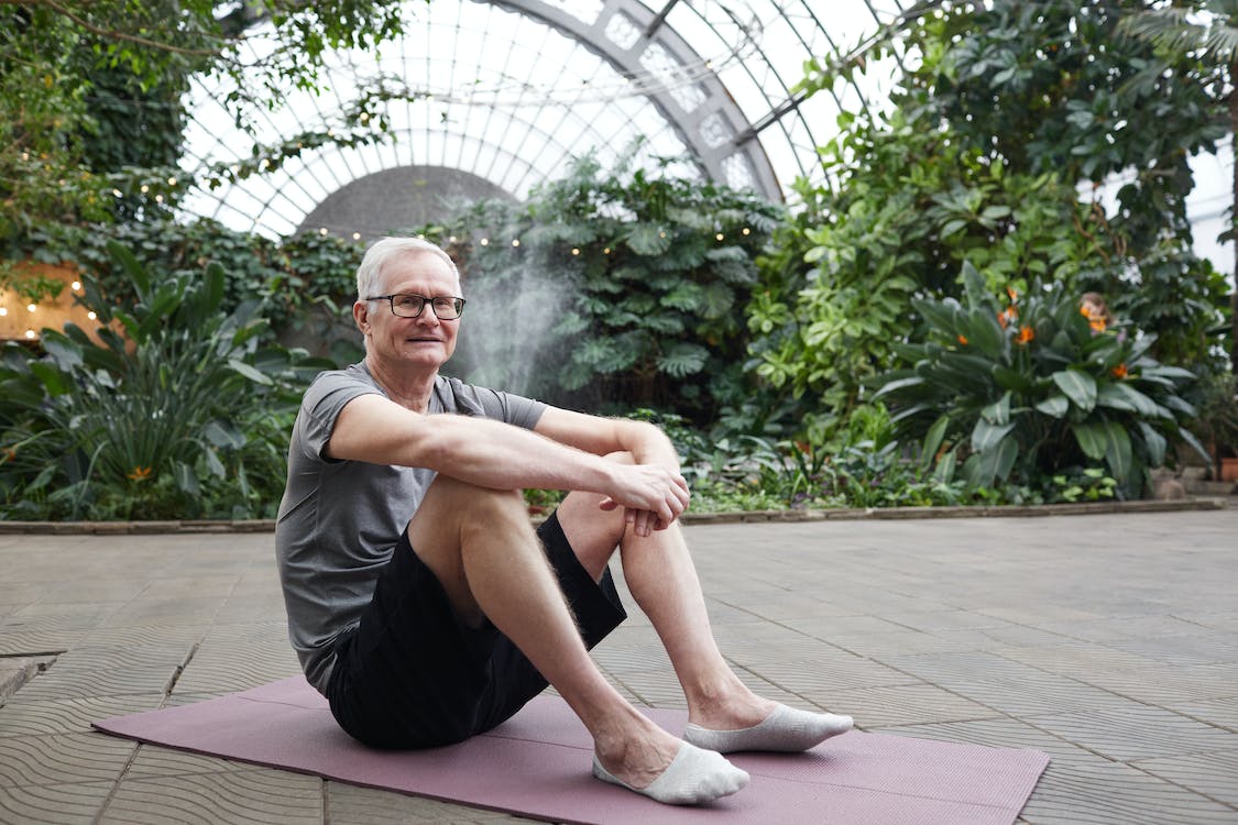 Older man sitting on a yoga mat